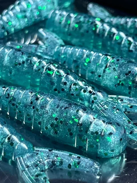 Teal curled-tail baits showing their ribs and sparkle