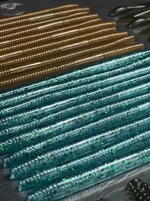 Brown and teal straight-body baits arranged in rows